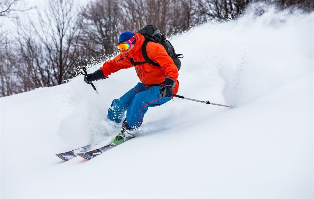 Skier carving through fresh powder snow