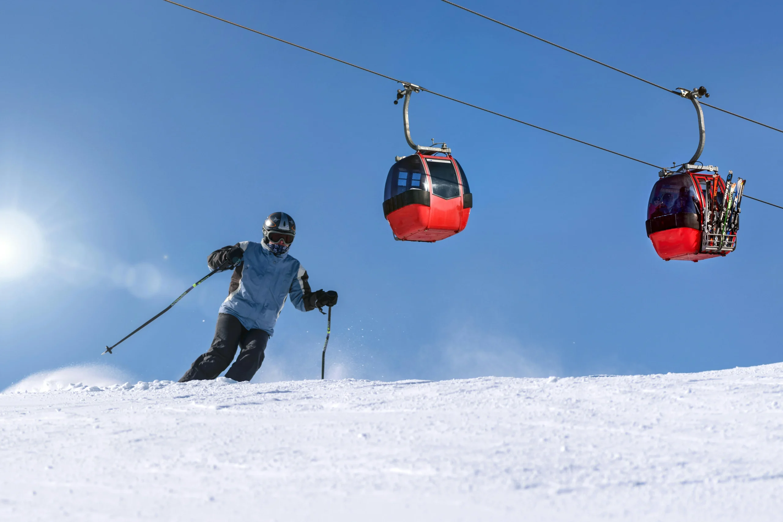 Person skiing under a cable car